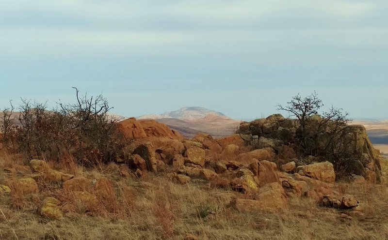 Mt. Scott in the distance, rises above nearby hills in the Wichita Mountains Wildlife Refuge. Seen looking east-northeast from high on Elk Mountain Trail.