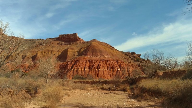 Looking southwest, Sunday Creek is dry when crossing it on Little Fox Canyon Trail. Red sandstone with white gypsum stripes was laid down in an earlier period than the higher yellowish brown rock.