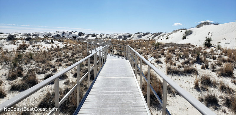 The wheelchair accessible Interdune Boardwalk surrounded by mounds of white gypsum sand.