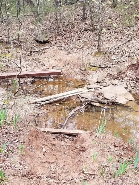 Washed out footbridge replaced with single plank across small creek. New Deal Trail, Lake Murray State Park, OK