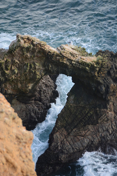 Watch the waves break through a rock arch formation at the end of Chimney Rock trail.