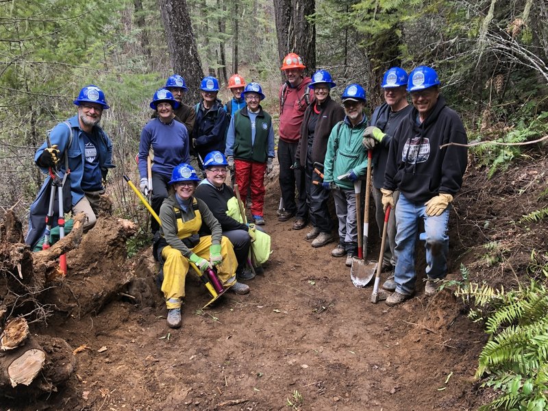 Blues Crew celebrating the repair of a large root ball hole in the trail.