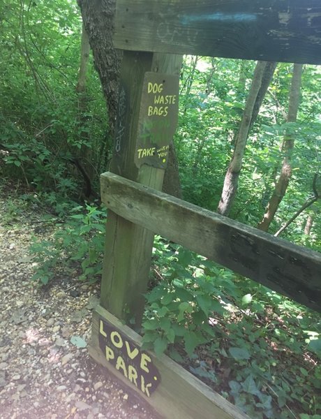 Small community signs on the safety fence just past the entrance to the trail.