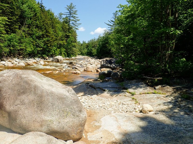 The trail juts out into the river on a large rock (looking upstream).