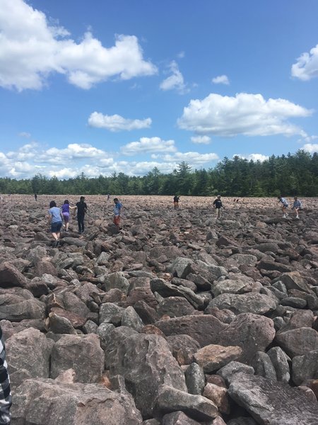 Visitors navigating their way across the boulder field.