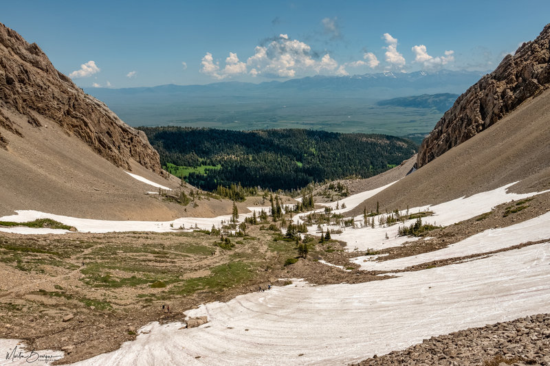 Looking down as you make the ridge below the peak. People at bottom of snow field for scale.