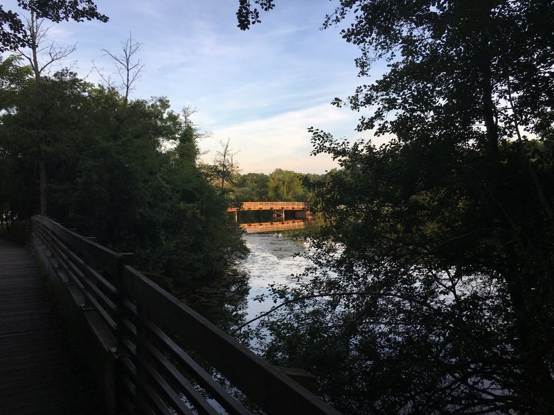 View of walking bridge toward wooden vehicle bridge.