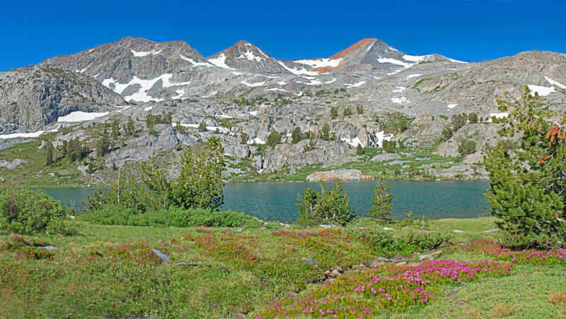 The near side of Lower Davis Lake is surround by green and flowery alpine meadows. You can reach Upper Davis Lake by climbing up the slopes on the far left-center of the picture.