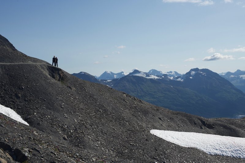 The trail narrows and wraps around the hillside and offers sweeping views of the mountains of the Kenai Peninsula.