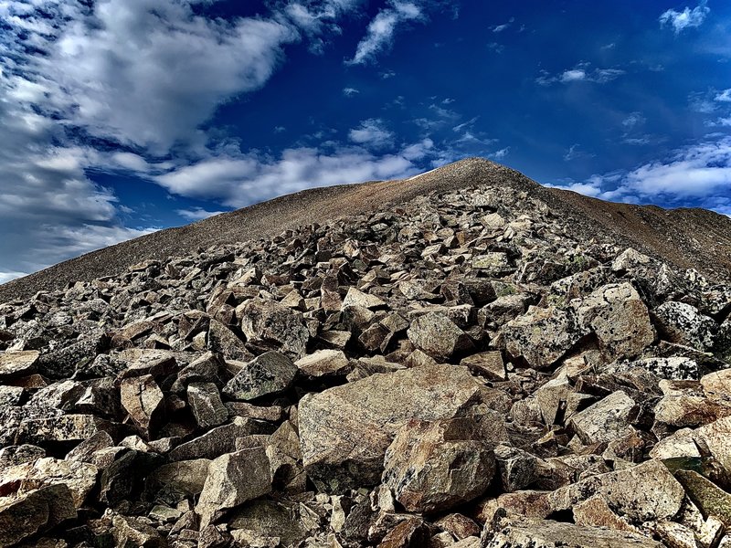 Above the saddle of Mount Cameron, this is your view up towards the false summit of Mount Democrat. Keep going and that snowfield dip down is your way up to the Summit. (Farther than it looks,  closer than it appears). Pay Attention! now to the weather!