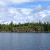 Standing on the south shore looking onward to the cliffs of Locator Lake at the end of Locator Lake trail.