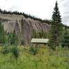 The Shalebanks Warden Cabin comes into view in a clearing in the fir forest, deep in the Jasper National Park backcountry.