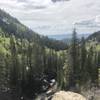 Hike up rocky incline, looking over valley