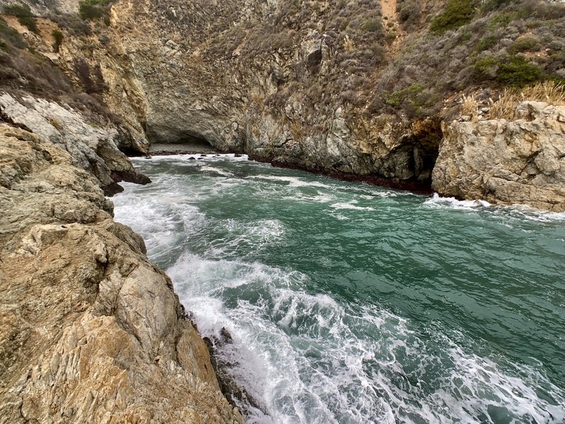 Waves crash into Partington Cove, a hidden inlet accessible via tunnel. A sign that warns against swimming or wading isn't a joke.