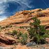 The sandy loop trail slowly descends further between towering rock walls.