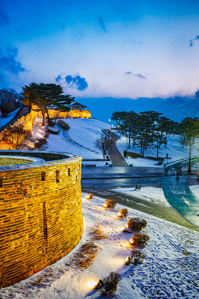 Dusk setting on the wall as snow falls