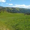 The spring green hills deep in the Joseph D. Grant County Park backcountry near the Canada de Pala Trail start. The trail is faint here as it goes through the grass meadows.