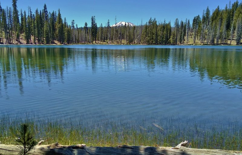 Lassen Peak in the distance to the west, is seen across Rainbow Lake close to Rainbow Lake Trail.