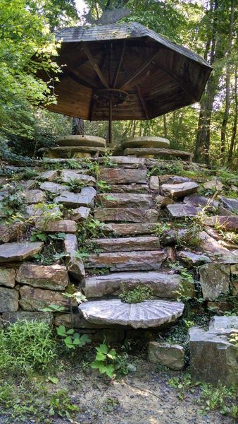 Stone steps leading to a grindstone table picnic area on the Chinqua-Penn Walking Trail.