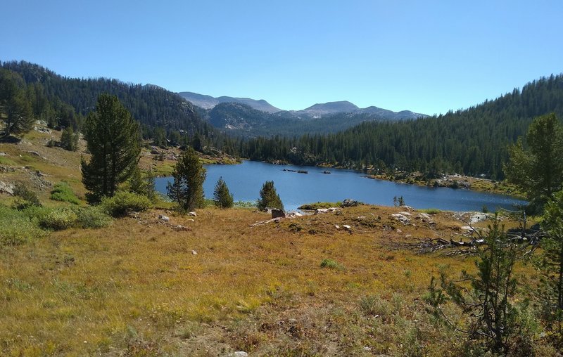 One of many small lakes in the high country, passed by Summit Lake Trail. Rugged peaks of the Wind Rivers are seen in the distance to the east here.