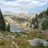 A picturesque small lake with the high peaks of the Wind Rivers in the distance, is seen looking north along the CDT.