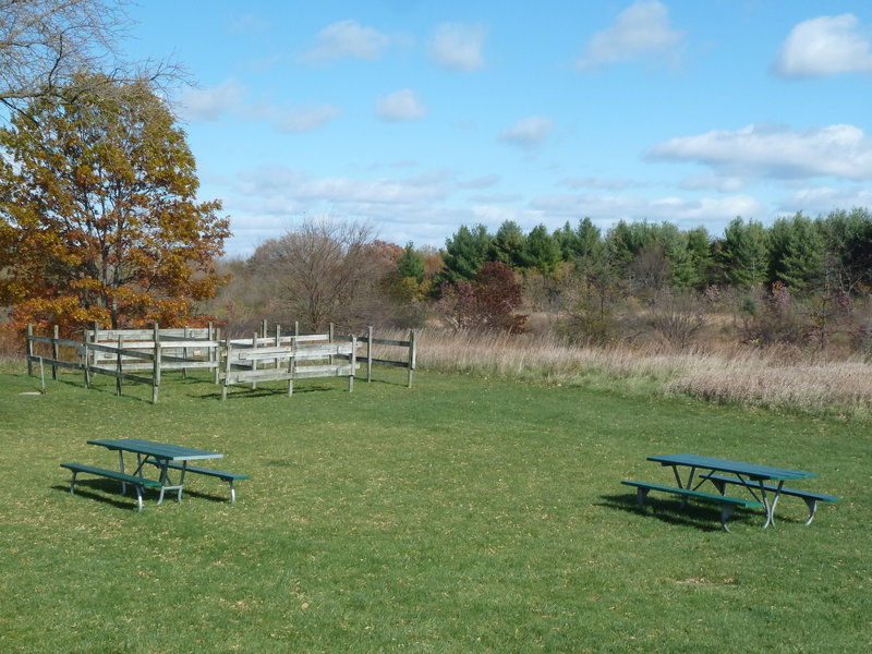 Equestrian holding area near parking lot with prairie in background.