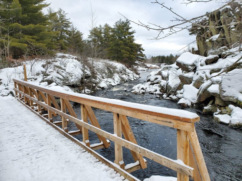 Peaceful snowy bridge and river.