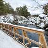 Peaceful snowy bridge and river.