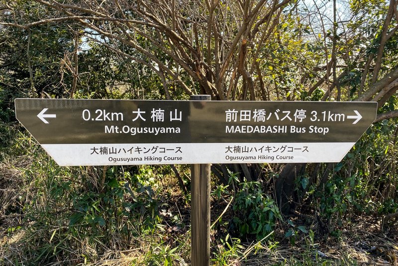 A sign near the top of Mt. Ogusu showing the direction and distance to the Maedabash bus stop via the trail to the Maedagawa Promenade.