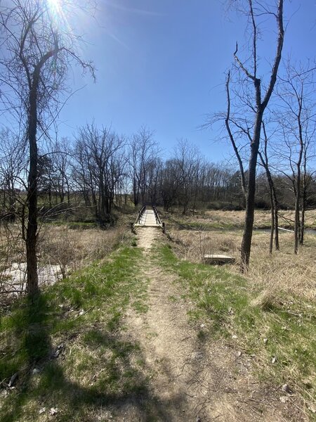 Foot bridge for the Old Barn Trail going over the inlet of the lake.