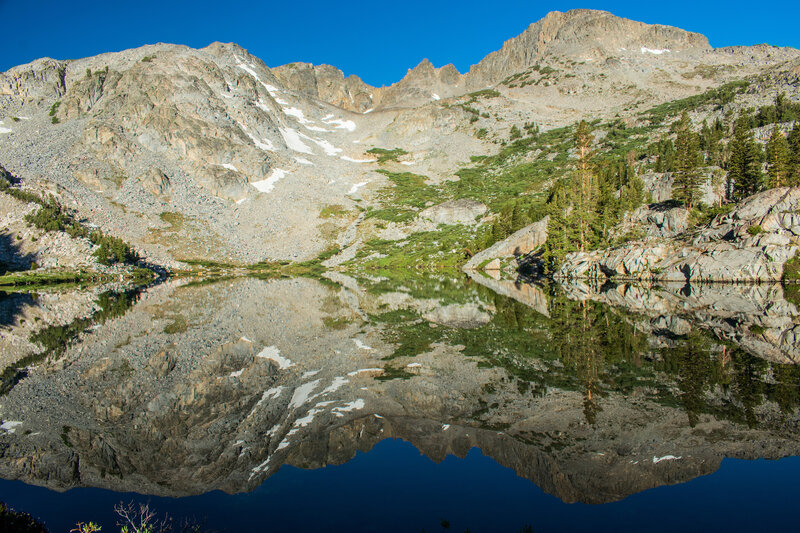 Morning reflection on Tower Lake. Trail to Tower Pass runs just below the trees on the left