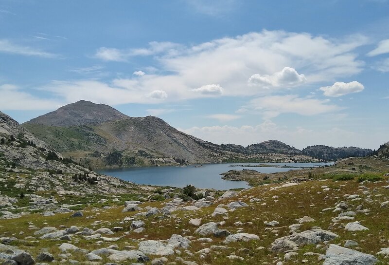 Looking back/southwest at Lake 10542 in the rocky, grassy alpine meadows when heading to the third lake, Lake 10741, on the way to Europe Pass.