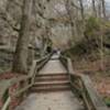 Long set of steps and boardwalk along rock wall.