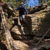 A hiker descends rocky trail.