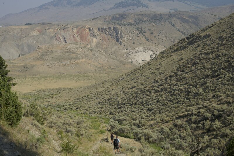 The trail descends steeply toward the fields outside Gardiner and the Yellowstone River.