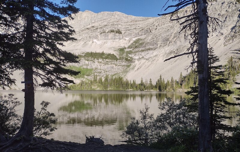 Window Mountain Lake and rock walls of the Great Divide lit up by early morning sunlight.