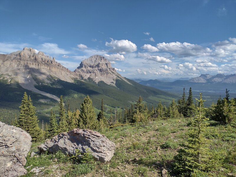 Seven Sisters, named for its seven spires on its top ridge, is on the left. Crowsnest Mountain is just left of center.  Seen looking southeast as the trail crests a ridge just below the Great Divide.