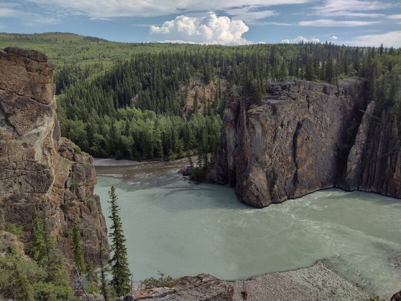 The broad, powerful, silty Smoky River (foreground, right to center) flows to meet the smaller, clearer Sulphur River (darker river just left of center) at the Sulphur Gates - the cliffs the Smoky River is flowing through here.