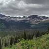 The view to the south as Gunsight Pass Trail traverses the southeast slopes of Fusillade Mountain. Mt. Logan, 9,239 ft., (left), Blackfoot Glacier sprawls out left of center, Jackson Glacier towards the right with most of it hiding behind a closer ridge.