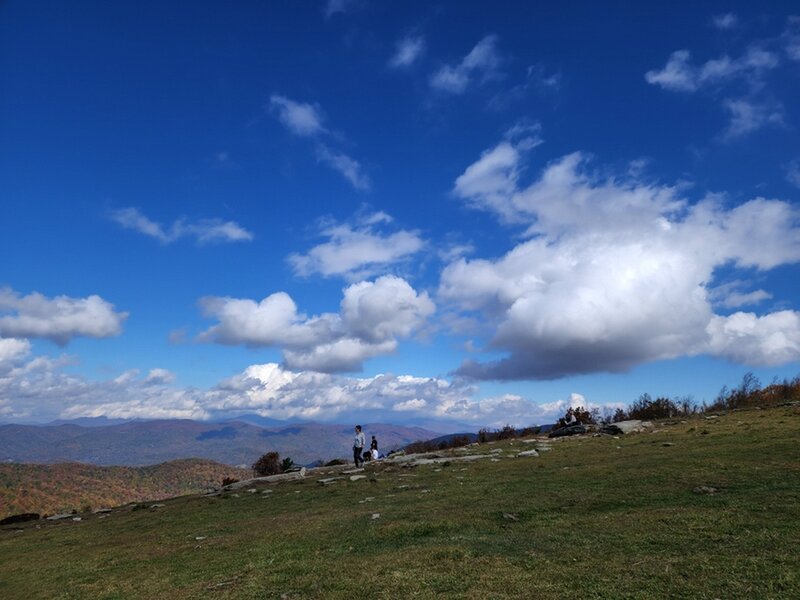 People on, and clouds over, Bearwallow Mountain.