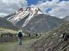 Hiker with snow capped peaks in the background.