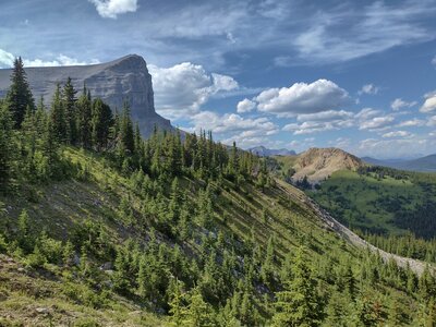 Beehive Mountain on the left/west, viewed from the southeast on the Great Divide Trail (GDT). Steep mountain meadows and valleys drop off to the east/right.