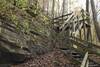 The trail descends a wooden staircase down to the cave entrance.