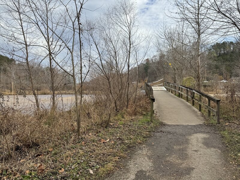 A bridge crosses an inlet for the lake and starts to head back toward the start of the trail.