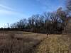 Going south along the edge of a large open pasture.