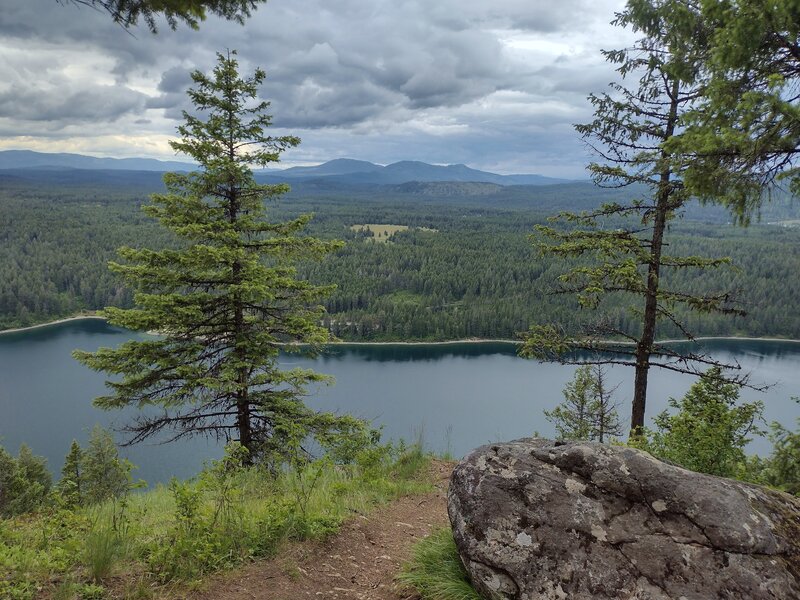 Dark emerald waters of Lake Pend O'reille's Idlewilde Bay below. Farragut State Park is on the opposite side of the bay. Seen looking north-northwest from Scout Trail's Lake Pend O'reille Viewpoint.