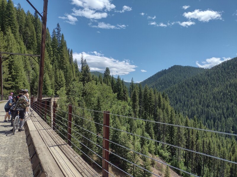 Bicyclists stop to admire the awesome views from high on Small Creek Trestle, a 120 foot high, 515 foot long, trestle along The Hiawatha Trail.