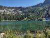 The sparkling, clear, blue-green waters of Snow Lake backed by the steep sides of the rocky ridges that surround it.