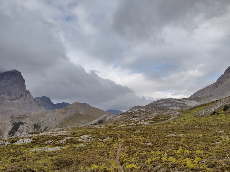 Approaching Surprise Pass from the south. Almost at the pass, peaks on the other side to the north, begin to appear. Pass is just behind near ridge (running center to right). It can get rather blustery up here in these high meadows and on the scree.