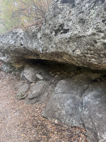 Rock formation capable of fitting a couple people underneath.